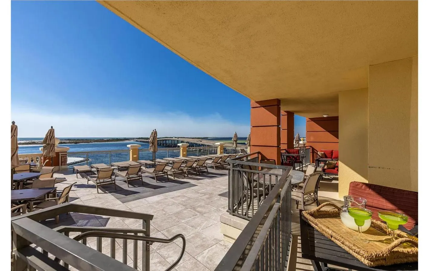 Terrasse avec mobilier d'extérieur et vue sur la mer.
