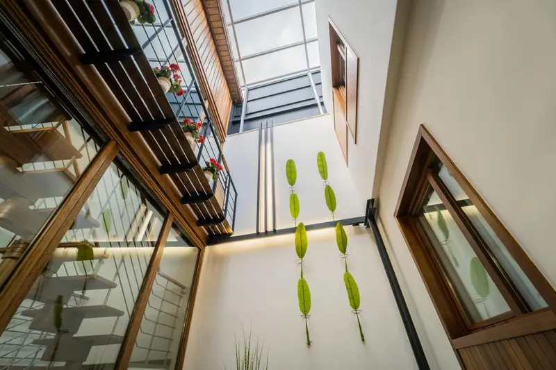 Vue d'un atrium intérieur avec des éléments décoratifs suspendus et des balcons en bois.