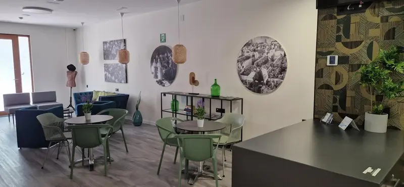 Espace de détente avec canapés, tables et décoration murale.