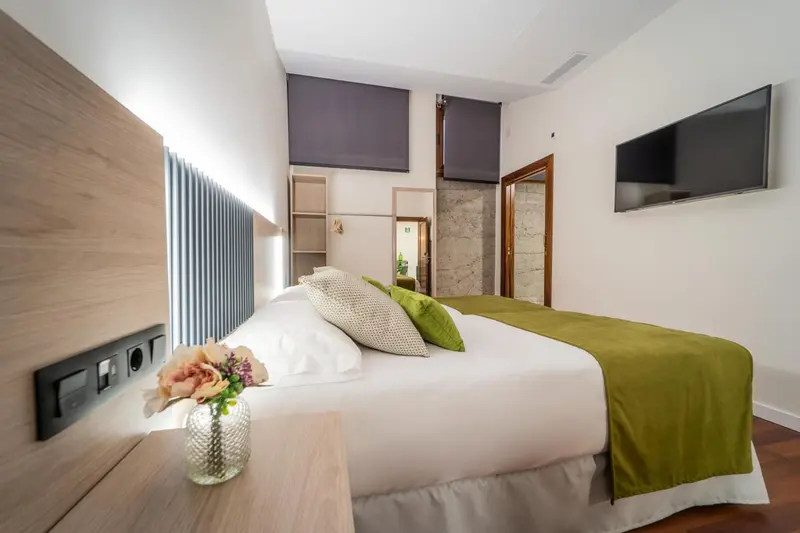 Une chambre lumineuse avec un grand lit et une décoration moderne.