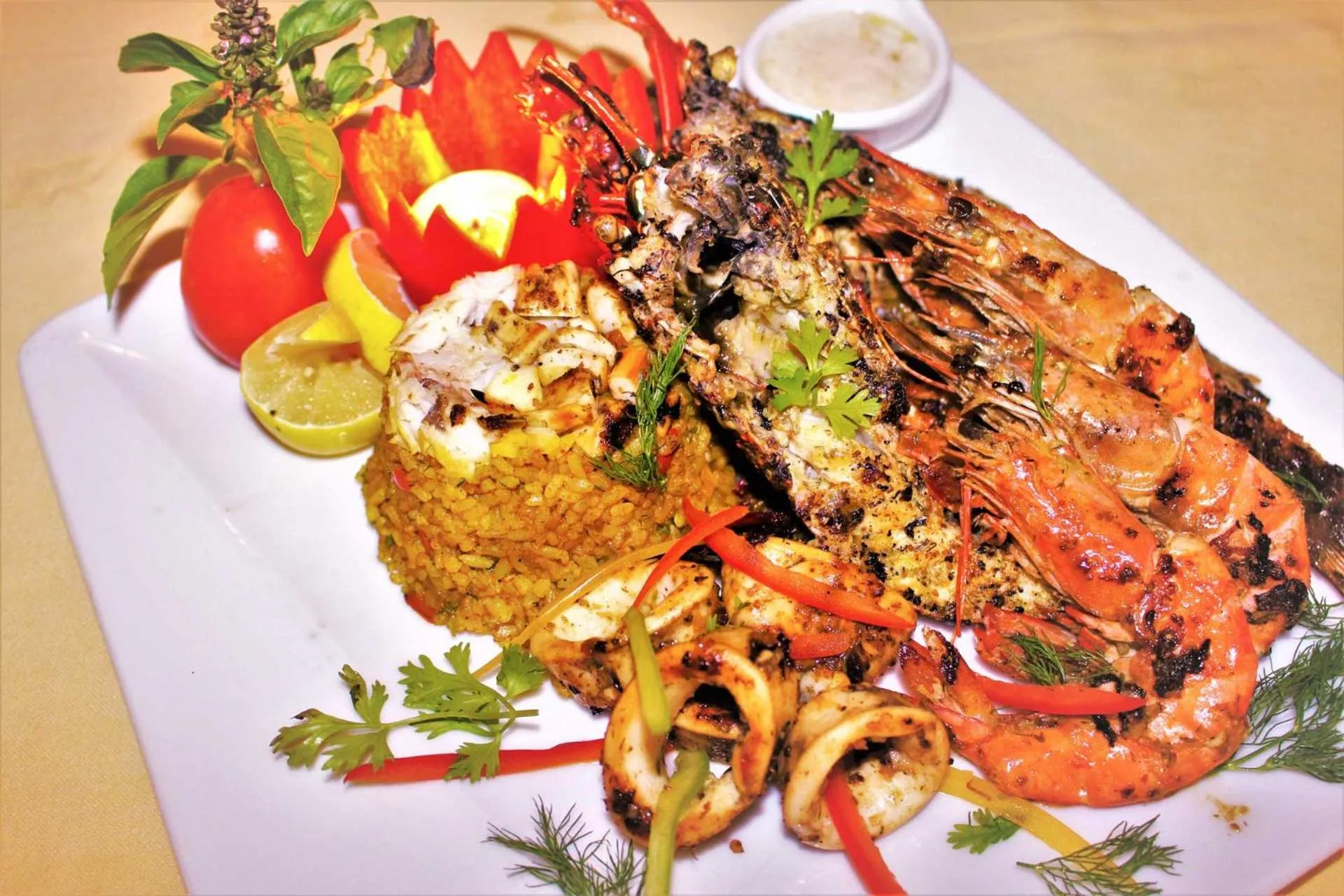 Assiette généreuse de fruits de mer grillés, riz et légumes frais.