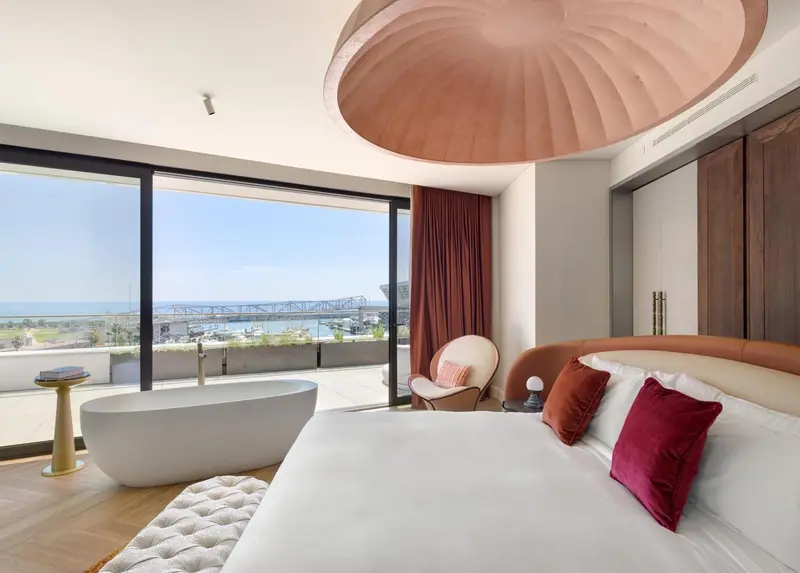 Chambre moderne avec baignoire et vue sur la mer.