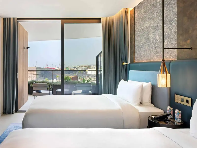 Chambre lumineuse avec un grand lit et une vue sur la mer.
