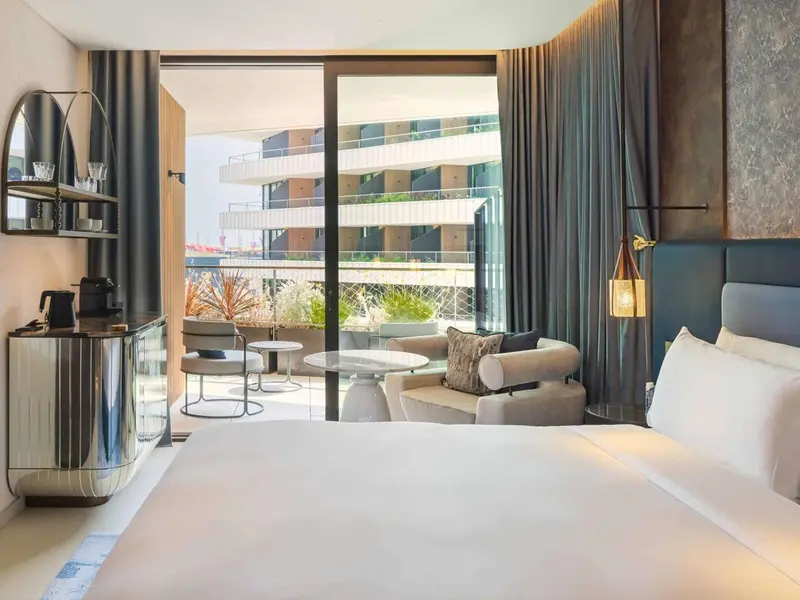 Une chambre lumineuse s'ouvre sur une terrasse avec vue sur la mer.