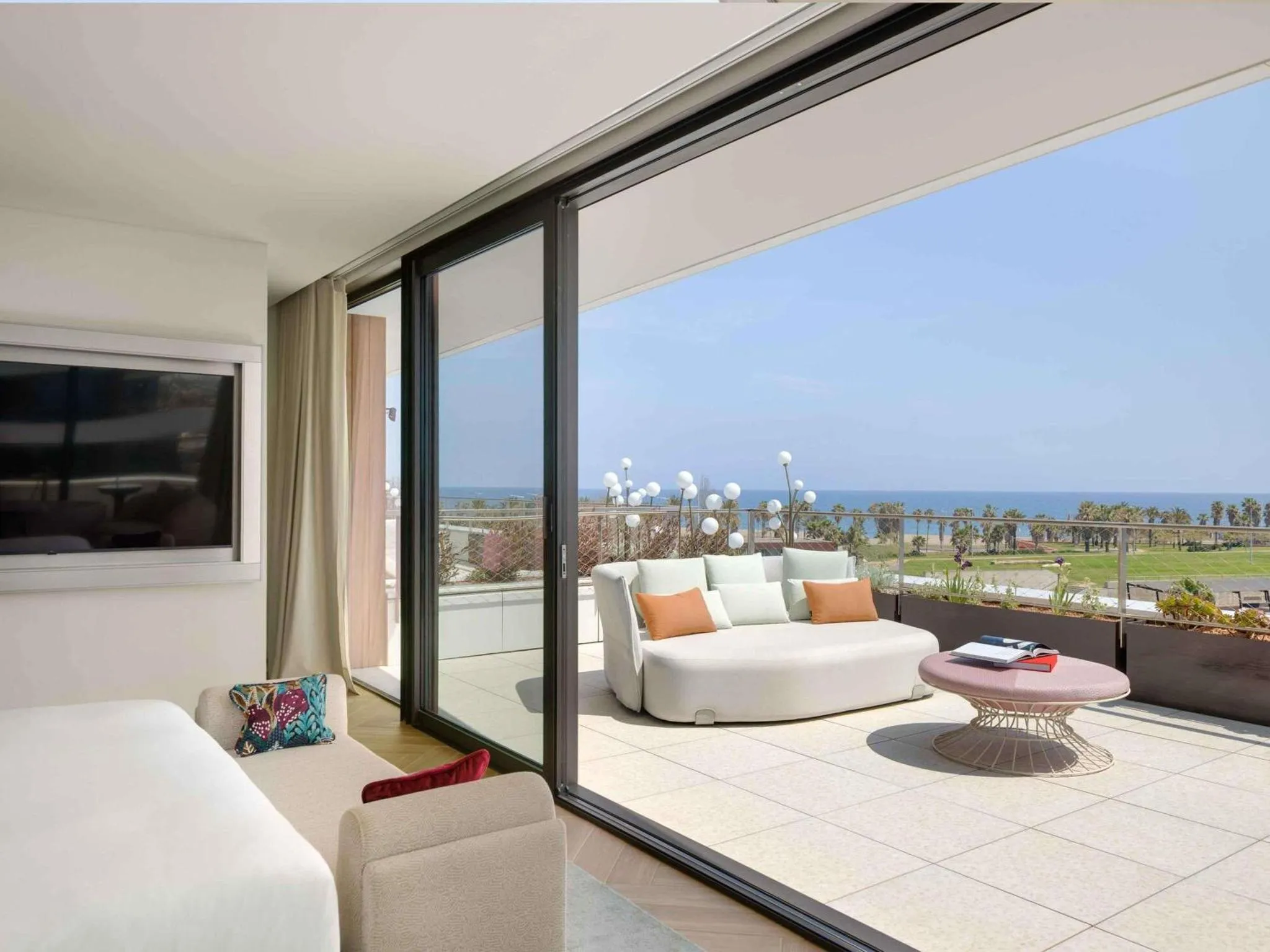 Espace de détente intérieur avec vue sur la mer et une terrasse.