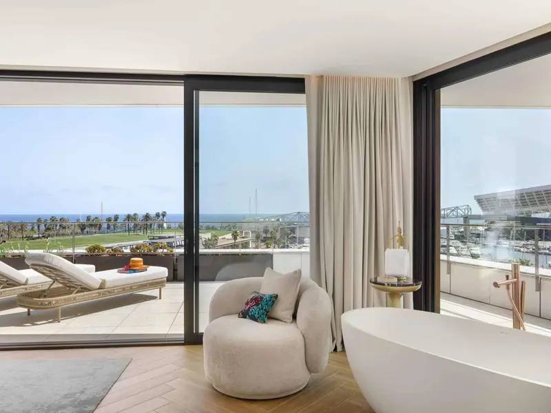 Une chambre lumineuse s'ouvre sur une terrasse avec vue sur la mer.