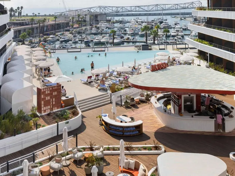 Vue aérienne d'une piscine avec des transats et un bar.