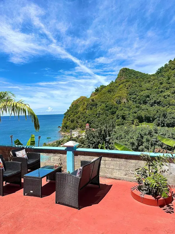 Terrasse avec mobilier d'extérieur donnant sur une vue côtière.