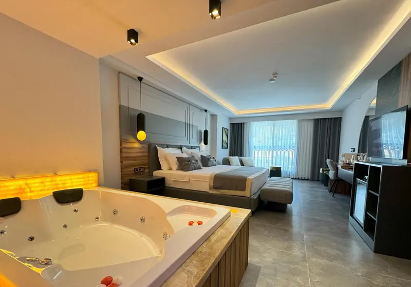Une chambre spacieuse avec un grand lit et un jacuzzi.