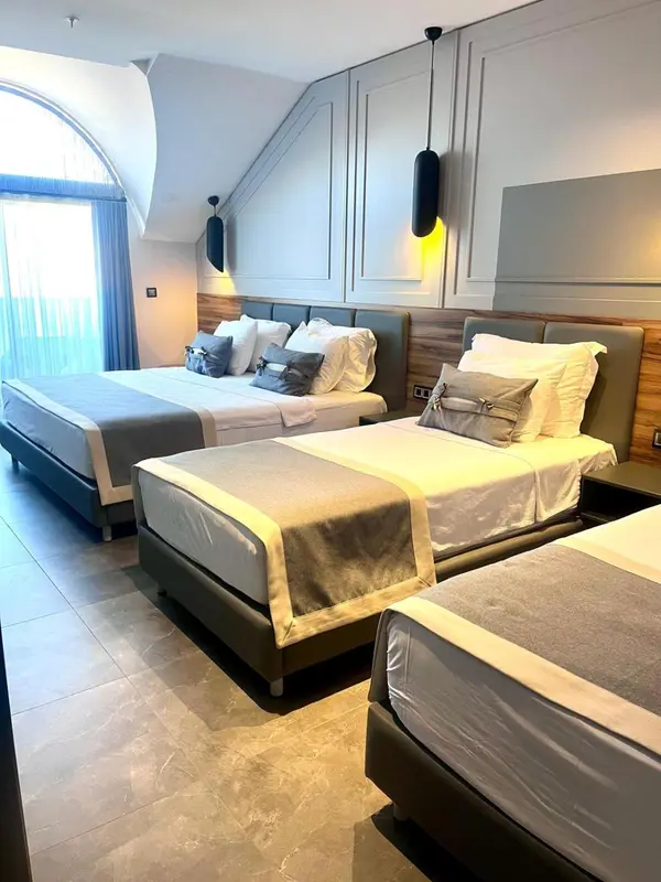 Une chambre d'hôtel moderne avec deux lits jumeaux et une décoration sobre.