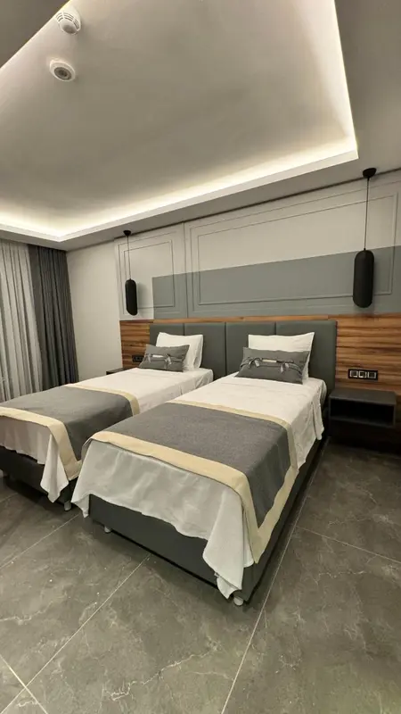 Une chambre avec deux lits simples et une décoration sobre.