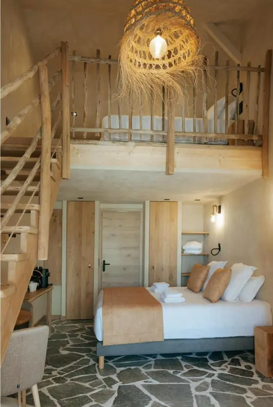 Une chambre à coucher avec un lit et un escalier menant à une mezzanine.
