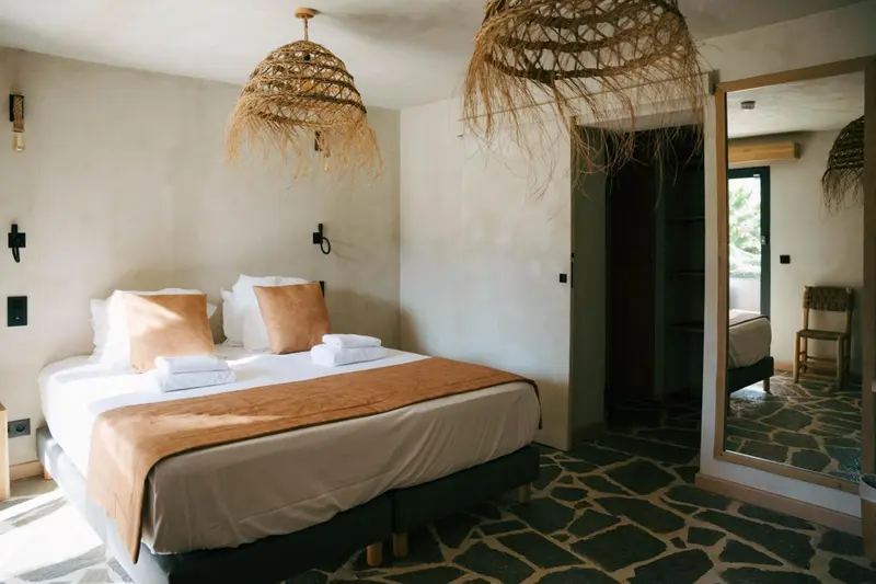 Une chambre à coucher lumineuse avec un lit double et une décoration naturelle.
