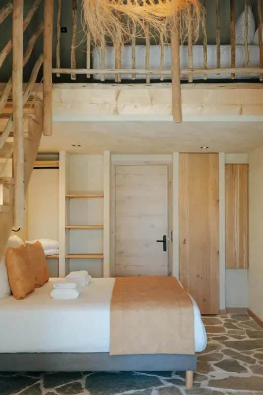 Une chambre à coucher avec un lit et un escalier menant à une mezzanine.