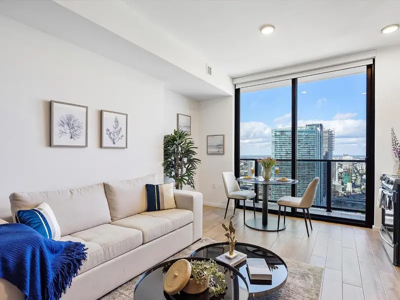 Un salon lumineux avec canapé et table basse offre une vue sur la ville.