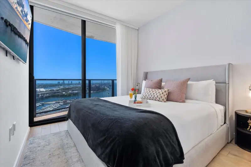 Chambre moderne avec un grand lit et une vue sur la ville.