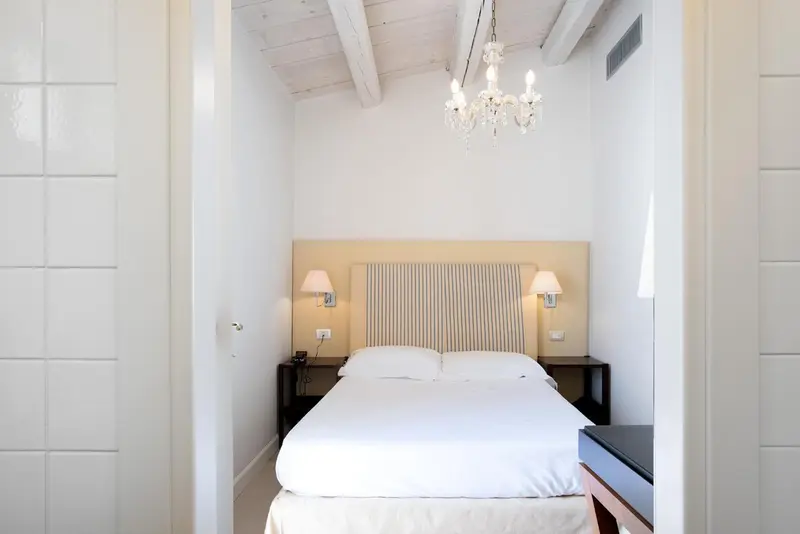Une chambre lumineuse avec un lit double et des tables de chevet.
