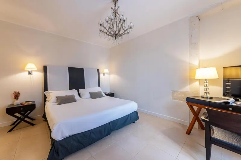 Une chambre lumineuse avec un grand lit et un bureau.