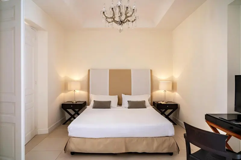 Une chambre lumineuse avec un grand lit et des tables de chevet.
