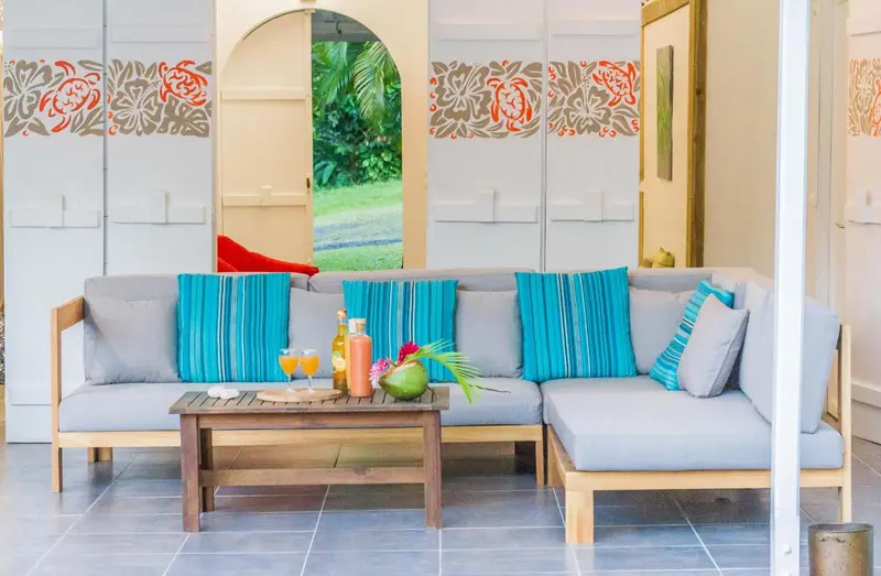 Un canapé d'angle turquoise et gris est installé dans un espace de détente lumineux.
