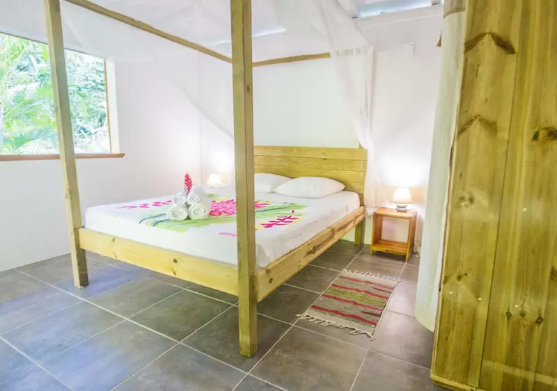 Une chambre lumineuse avec un lit à baldaquin et une décoration florale.