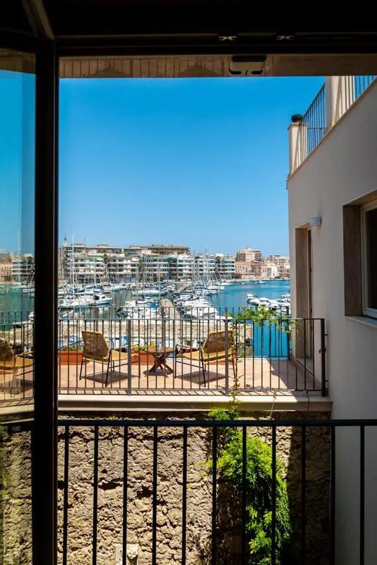 Vue sur un port de plaisance depuis une terrasse ensoleillée.