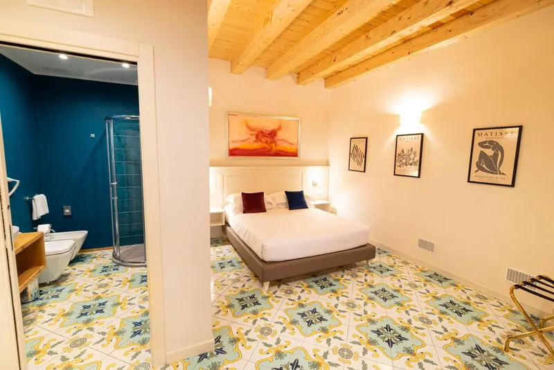 Une chambre lumineuse avec un lit et une salle de bain attenante.