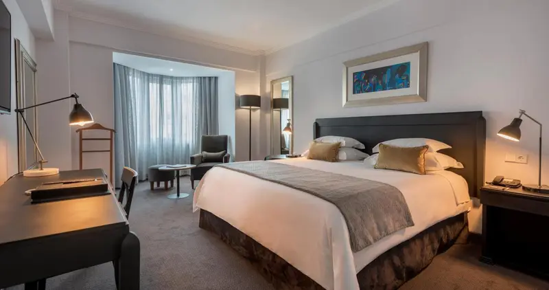 Une chambre d'hôtel moderne avec un grand lit et un coin salon.