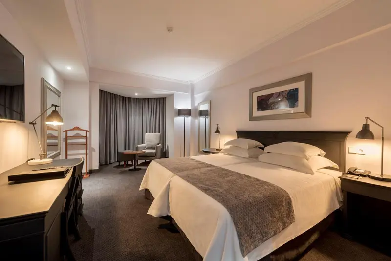 Une chambre d'hôtel moderne avec un grand lit et un coin salon.