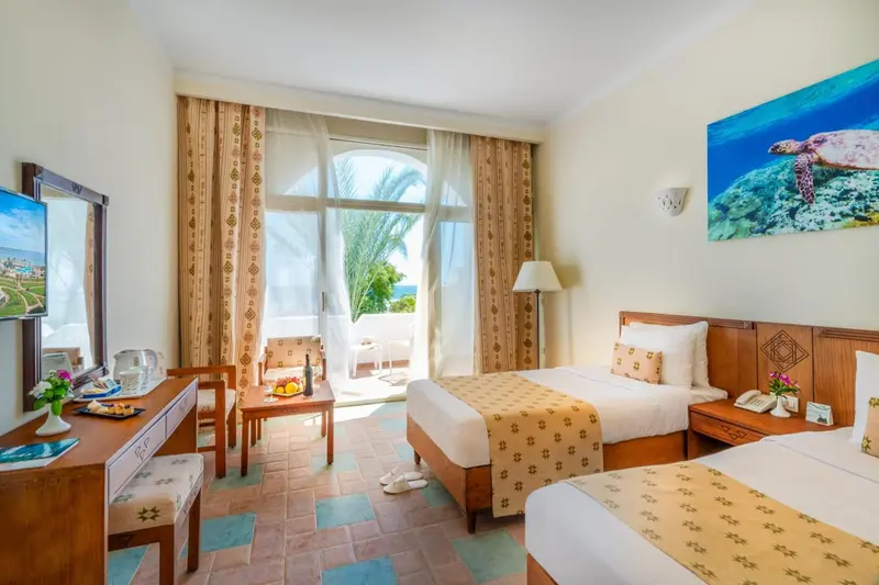 Chambre lumineuse avec vue sur la mer et un espace repas.