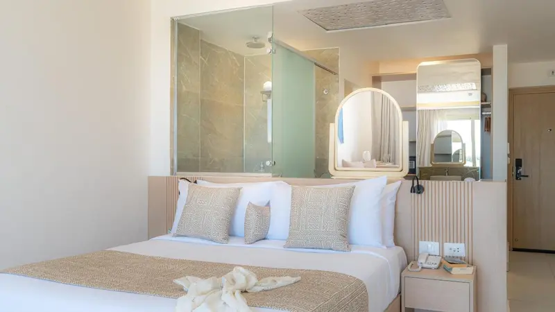 Une chambre lumineuse avec un grand lit et une salle de bain attenante.
