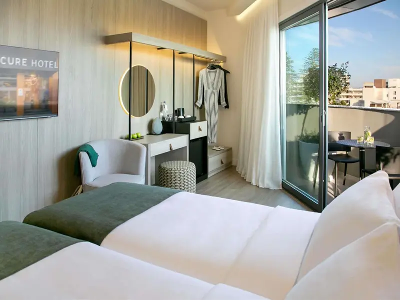Chambre lumineuse avec un lit confortable et un accès à une terrasse.