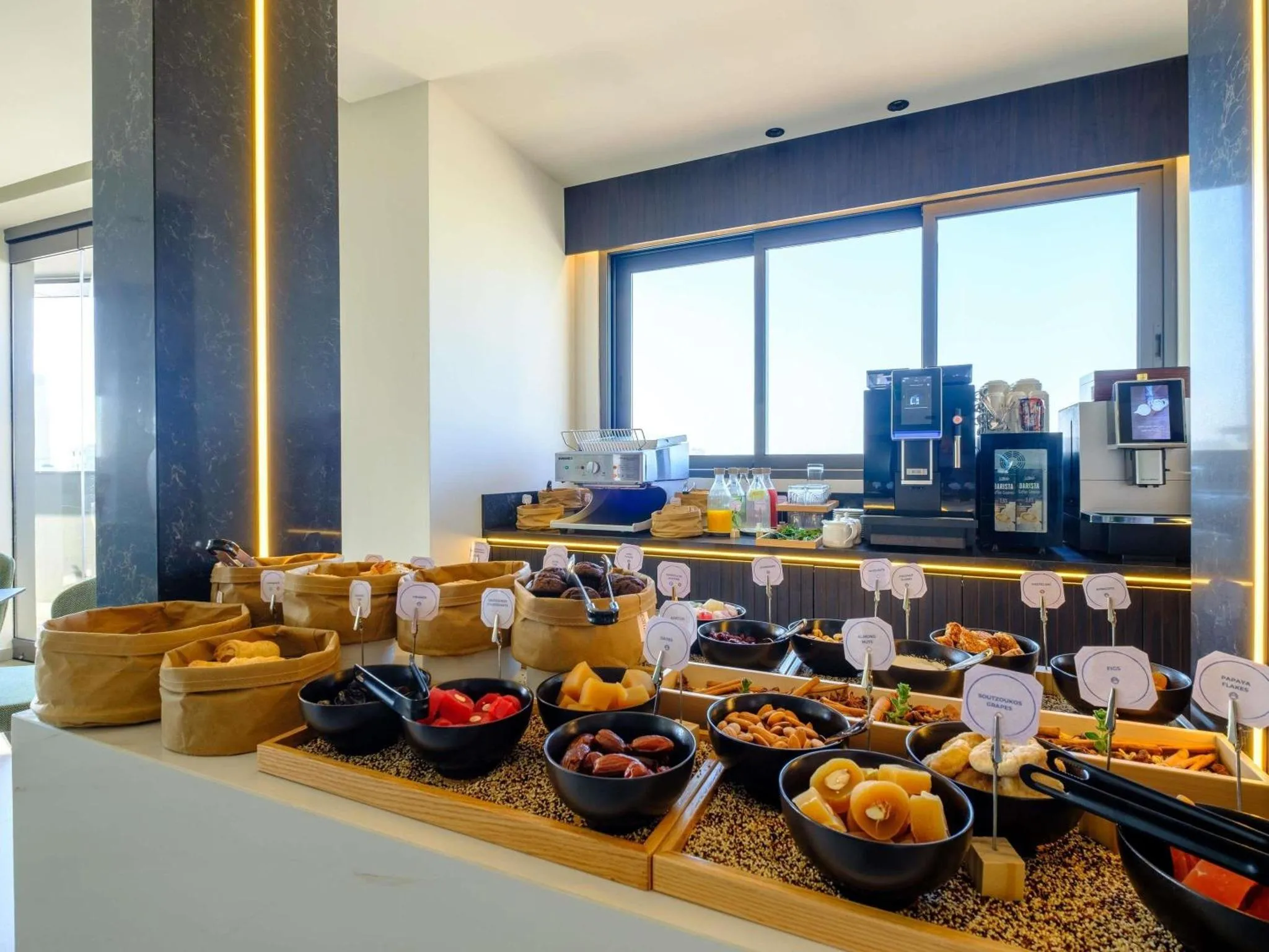 Un buffet propose une variété de pâtisseries, de fruits et de céréales.