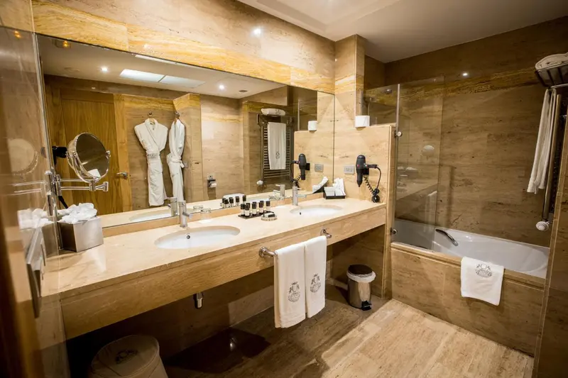 Une salle de bain spacieuse avec deux vasques et une baignoire.