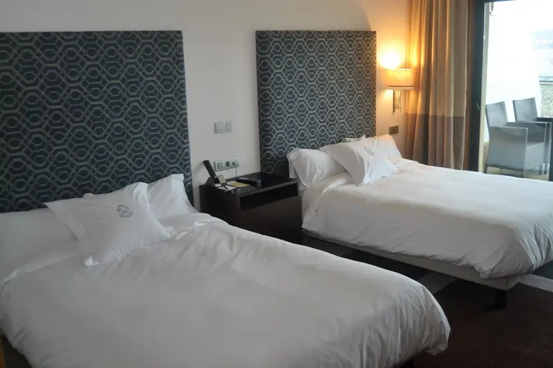 Une chambre avec deux lits simples et une table de chevet.
