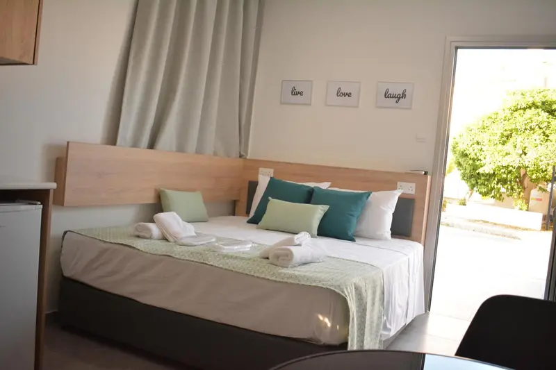 Une chambre lumineuse avec un grand lit et un accès à une terrasse.