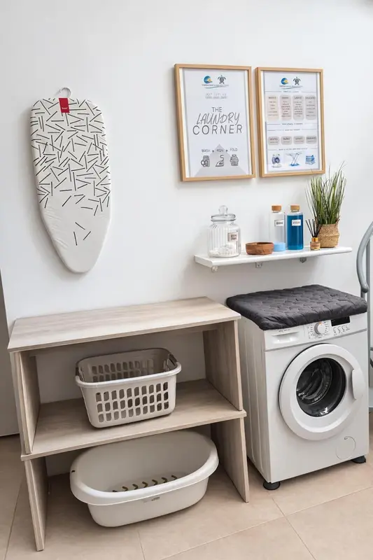 Une buanderie avec un plancher clair et des équipements de lessive.