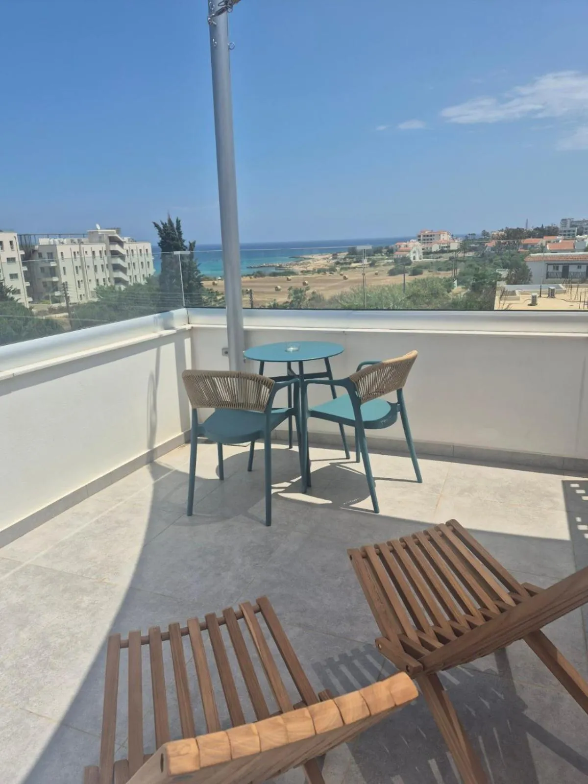 Terrasse avec mobilier d'extérieur et vue sur la mer et la ville.