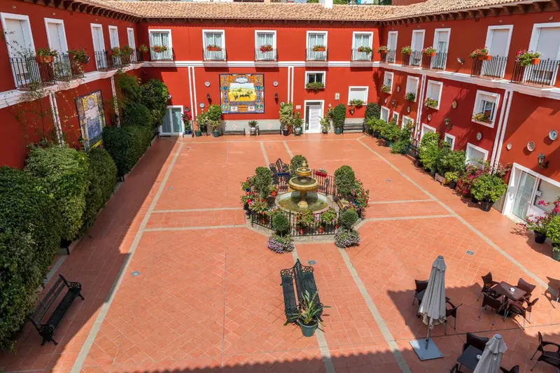 Vue aérienne d'une cour intérieure ornée d'une fontaine et de plantes.