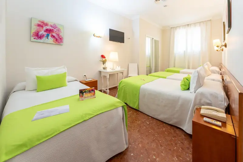 Chambre lumineuse avec deux lits simples et une décoration florale.