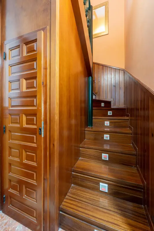 Un escalier en bois monte vers l'étage supérieur.