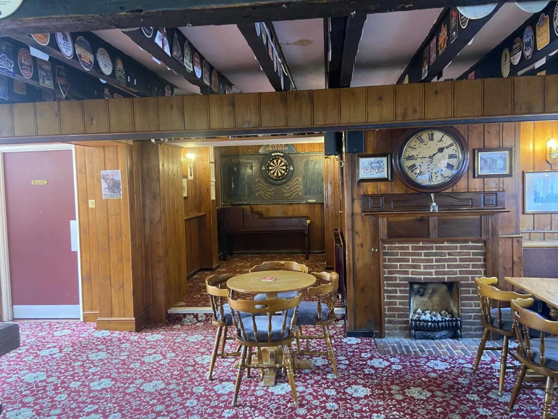 Une salle de restaurant chaleureuse avec des tables en bois et une cheminée.