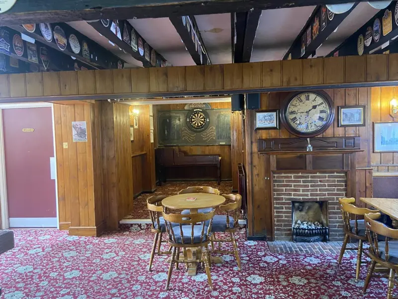 Une salle de restaurant chaleureuse avec des tables en bois et une cheminée.