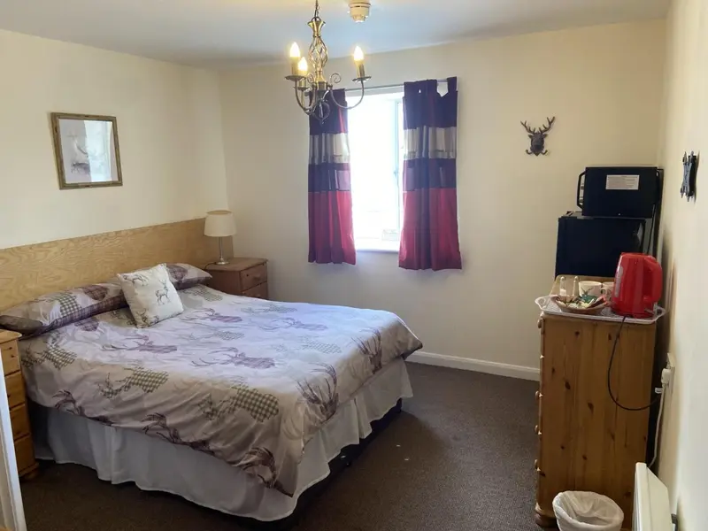 Une chambre à coucher lumineuse avec un lit fait et une commode.