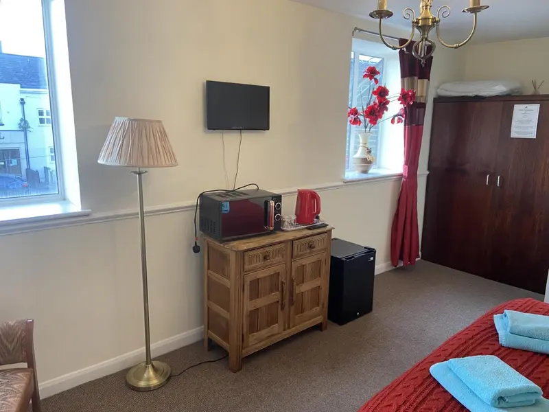 Une chambre lumineuse avec un meuble TV et une commode en bois.