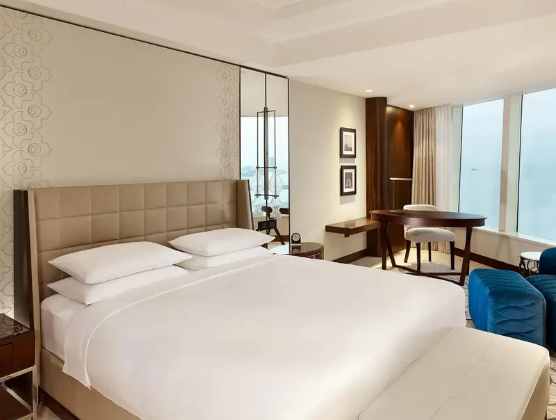 Une chambre d'hôtel lumineuse avec un grand lit et un bureau.