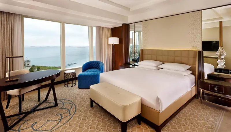 Une chambre lumineuse avec un grand lit et une vue sur la mer.