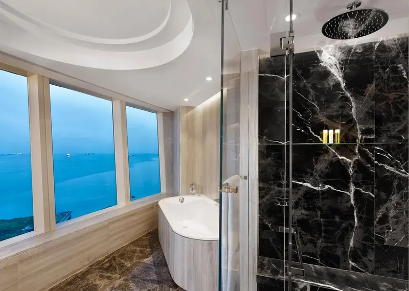 Une baignoire et une douche à l'italienne offrent une vue sur la mer.