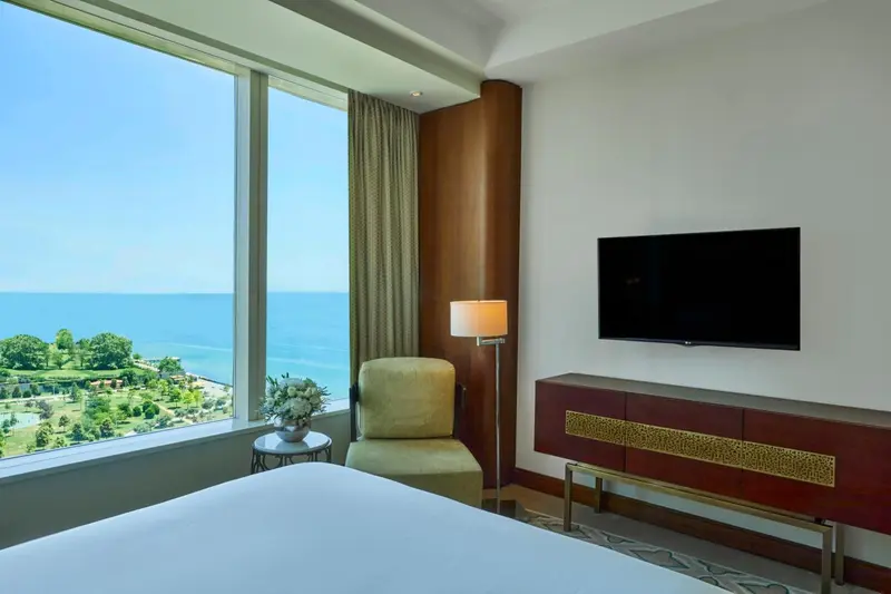 Une chambre lumineuse avec vue sur la mer et un coin lecture.