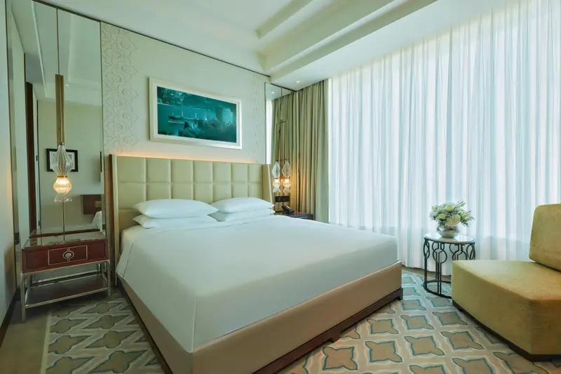 Chambre lumineuse avec un grand lit et une décoration sobre.